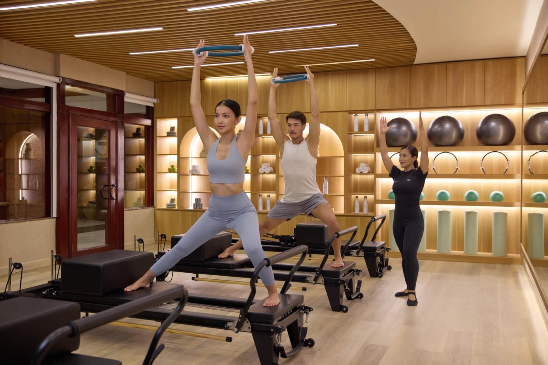 couple are doing the pilates with an instructor